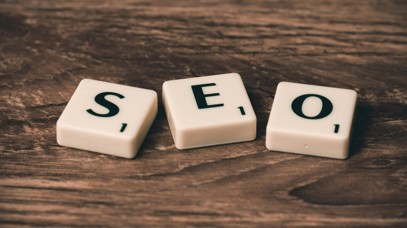 Scrabble tiles spelling 'SEO' on a wooden surface. Ideal for digital marketing themes.
