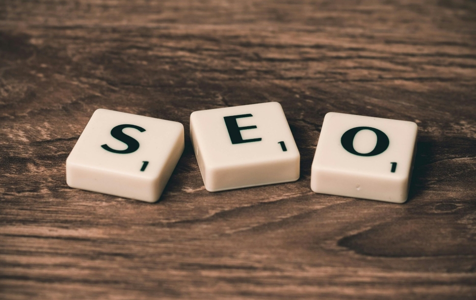 Scrabble tiles spelling 'SEO' on a wooden surface. Ideal for digital marketing themes.